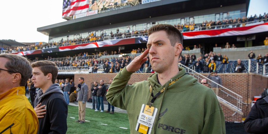 Airman 1st Class Andrew Snively salutes during the national anthem.