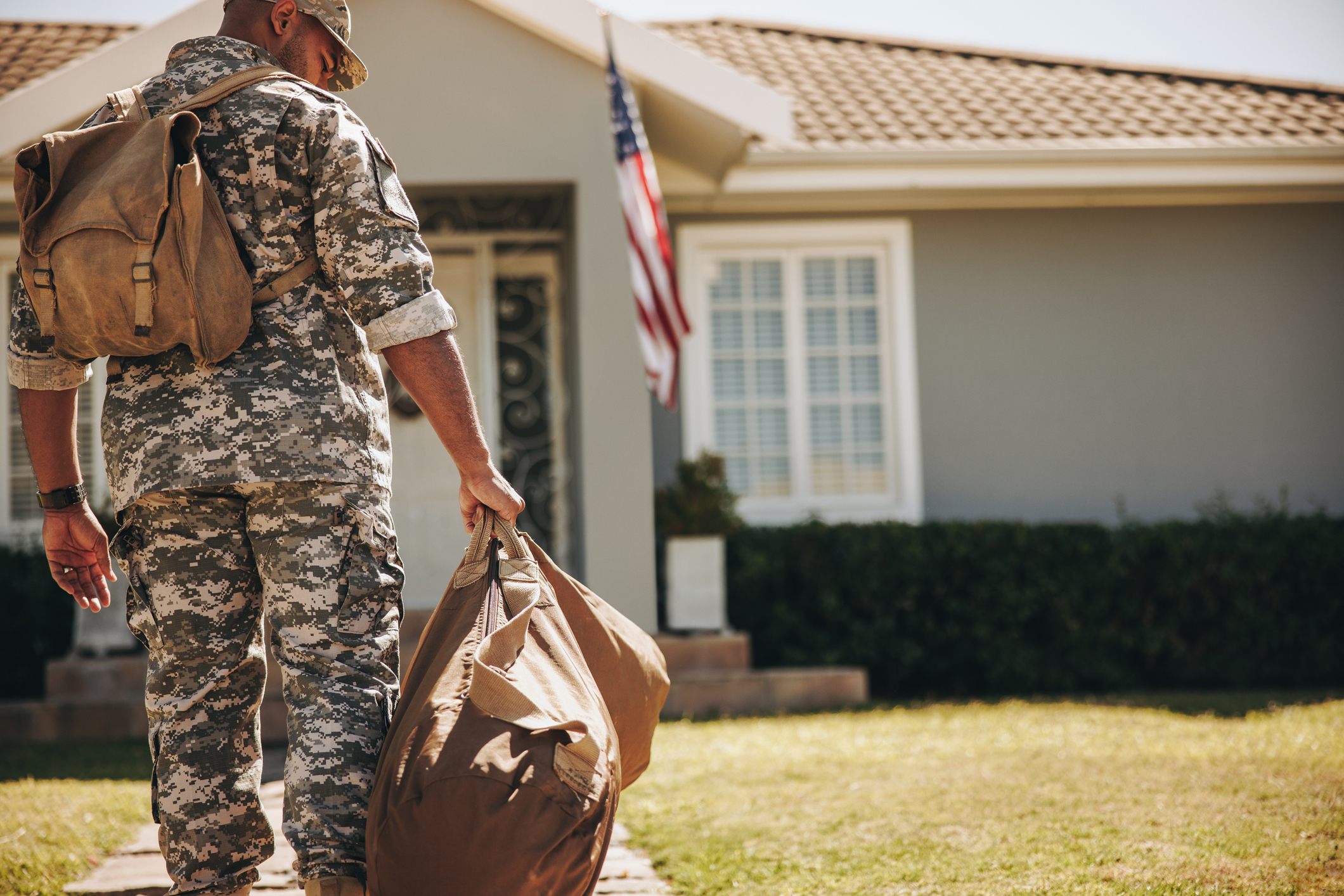 Soldier with PCS orders standing in front of his new home. 