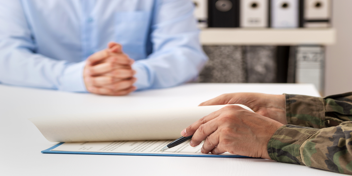 Close up of soldier inspecting paperwork with professional.
