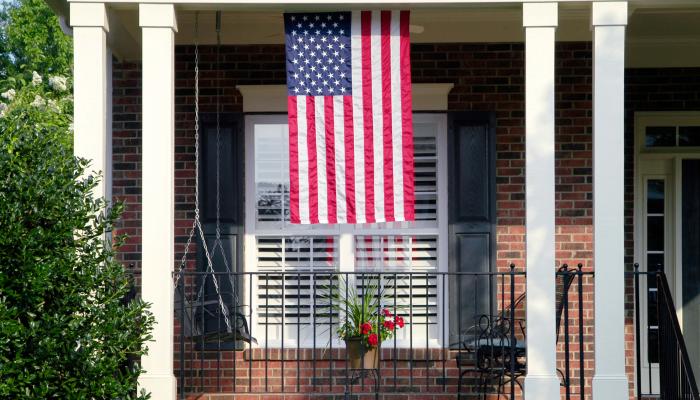American flag hanging from a home's front porch.