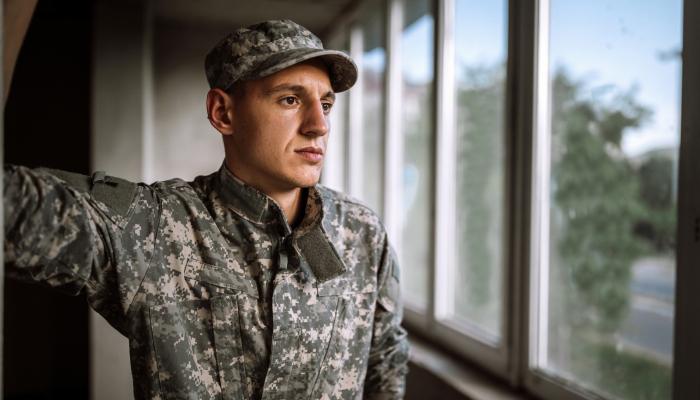 Young soldier gazing out of a window.