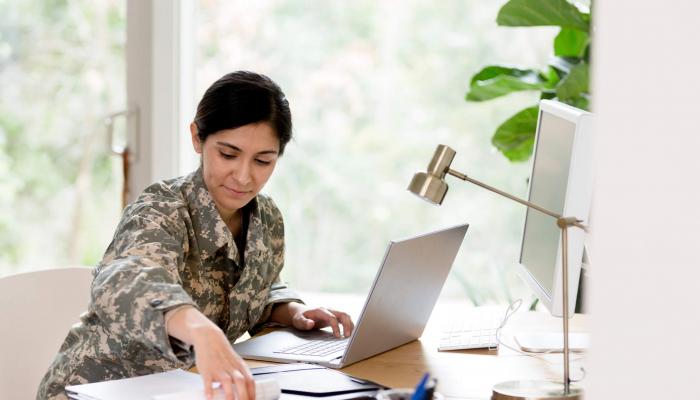 Woman soldier working at a modern desk.