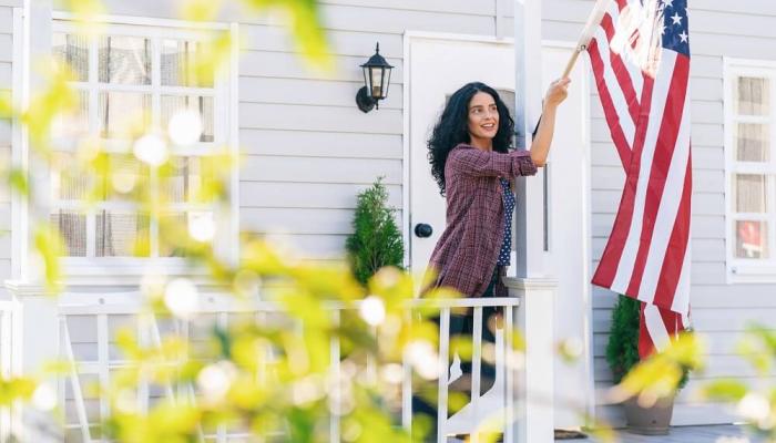 Veteran hanging American Flag on her front porch.