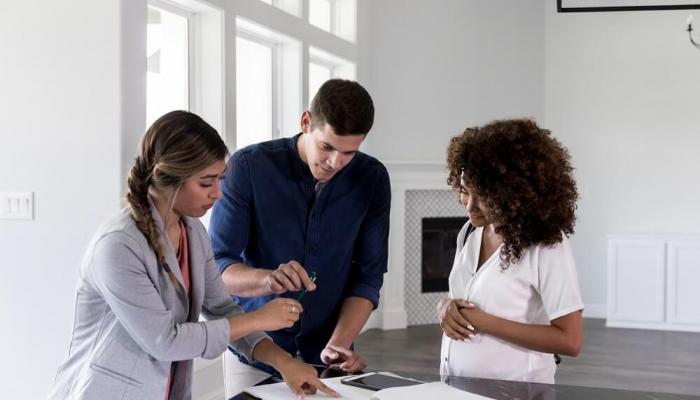 Couple reviewing paperwork with a real estate agent.