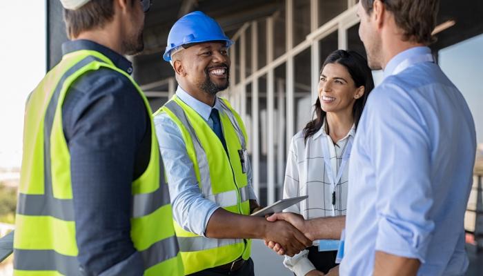 Couple greets contractors on a home construction site.