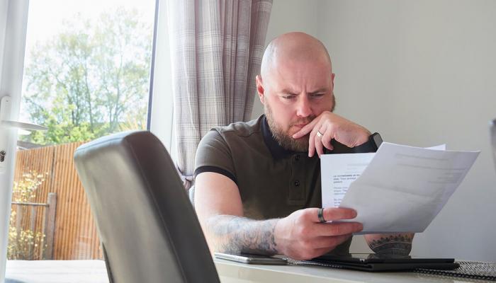 Man contemplating debt paperwork. 