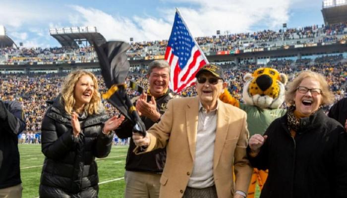 Football fans cheer for major Harvey B. Young Jr.