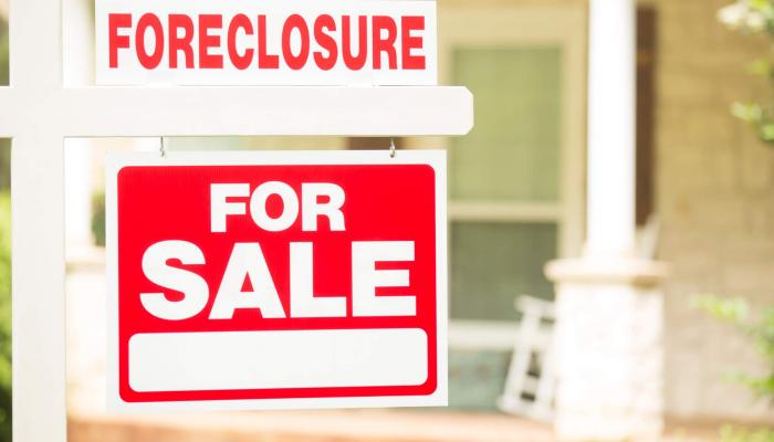 house with foreclosure sign