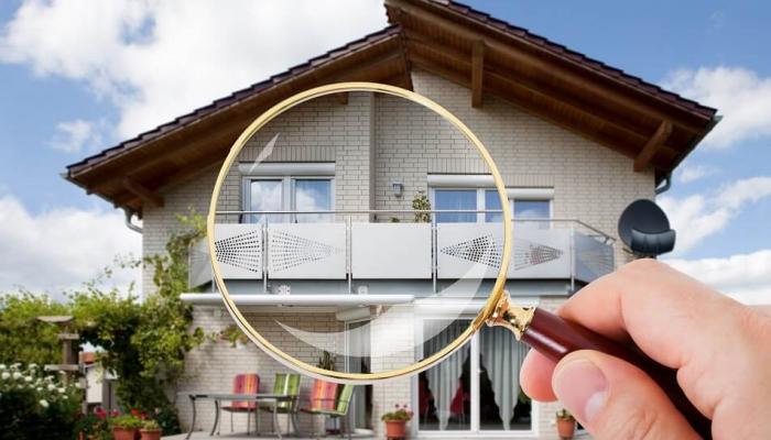 Looking at a home through a magnifying glass.
