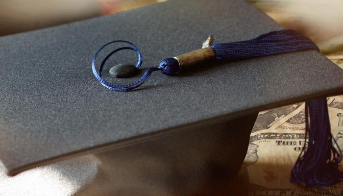 student graduation hat on loan money