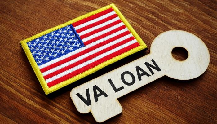 Close up of American flag patch next to a wood-carved key that says VA LOAN.