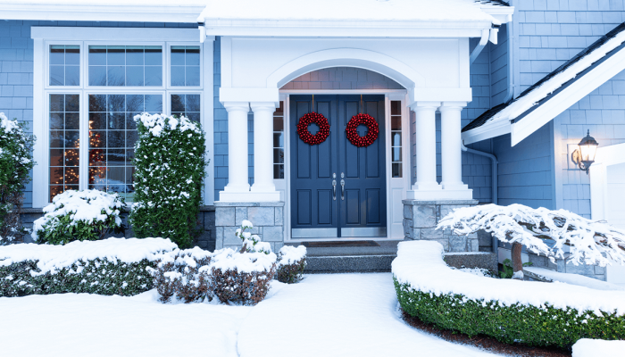 Front of nice home covered in winter snow.