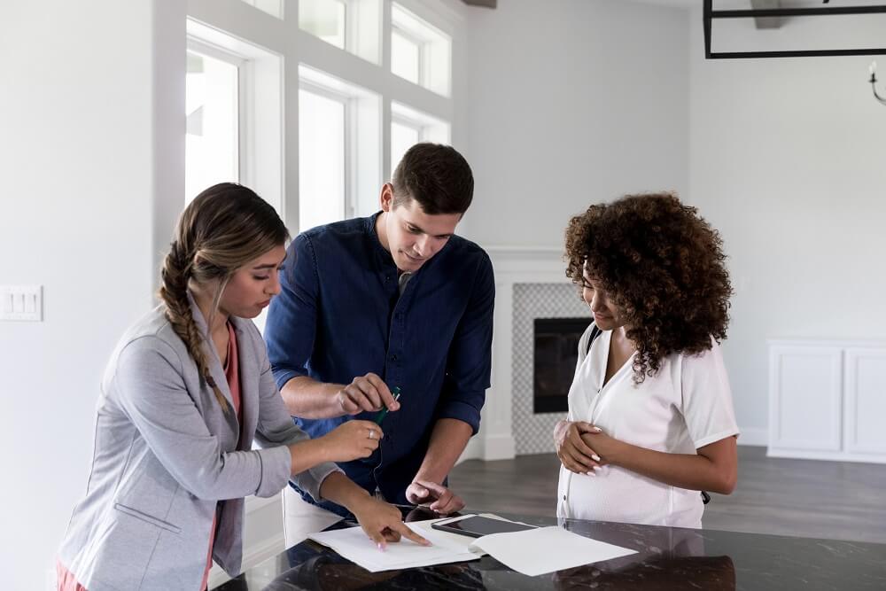 Couple reviewing paperwork with a real estate agent.