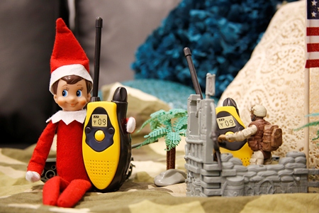 Elf on a Shelf talks to another soldier on walkie talkies