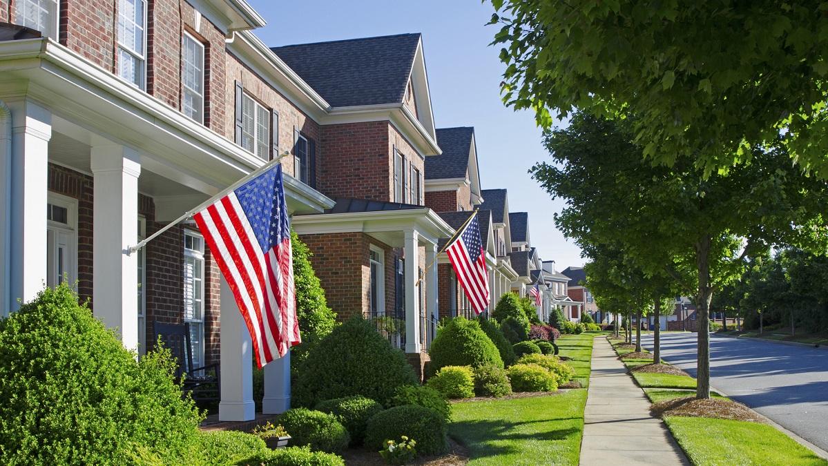 Row of residential homes with American flags.
