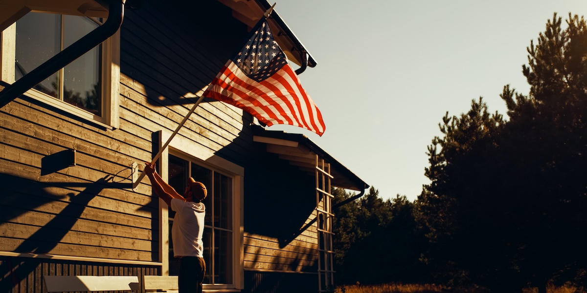Man displaying the American flag on the outside of his home.