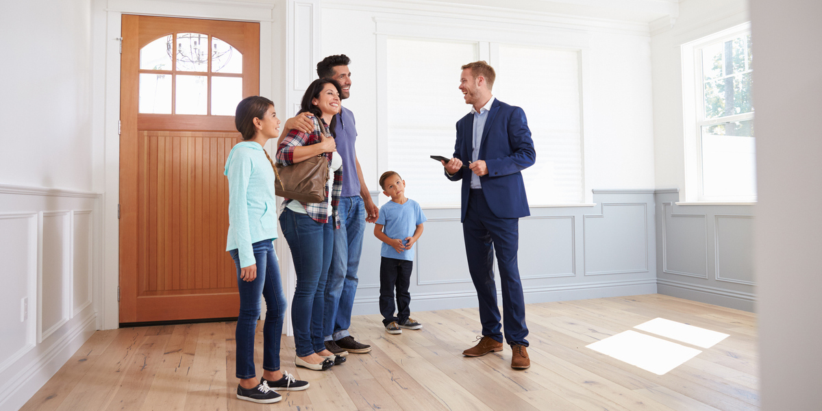 A real estate agent showing a family a home.