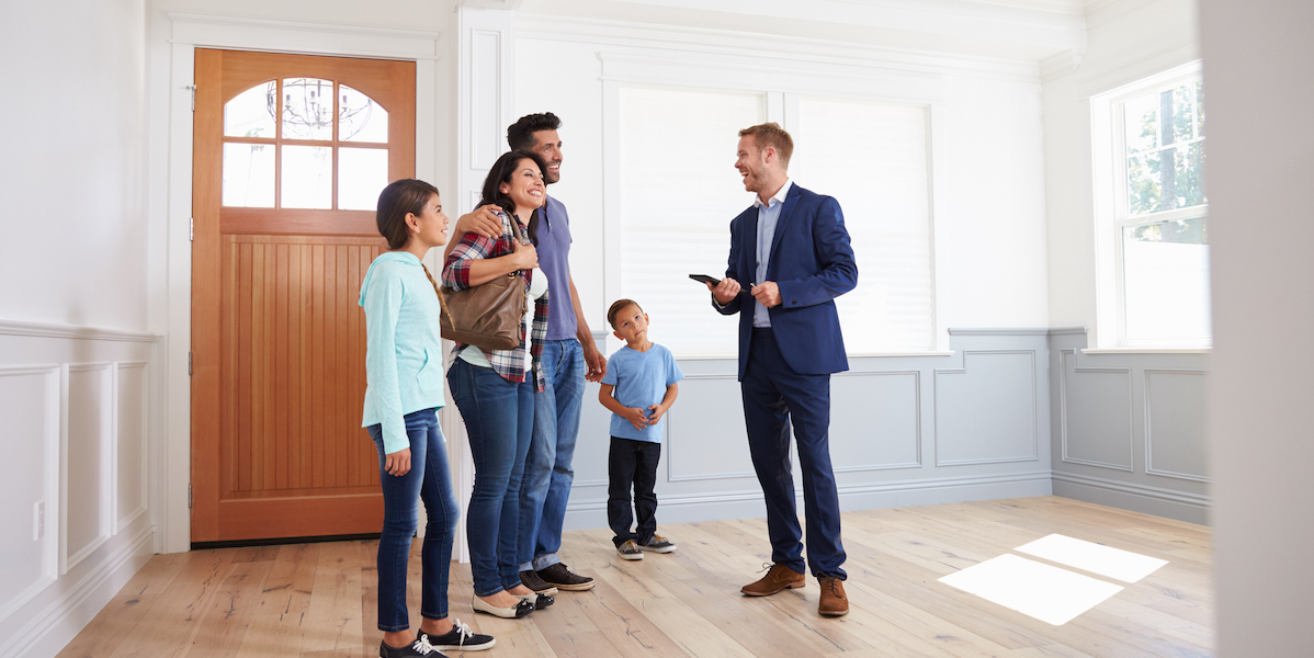 A real estate agent showing a family a home.
