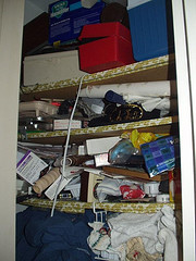 Cluttered closet stuffed with items.