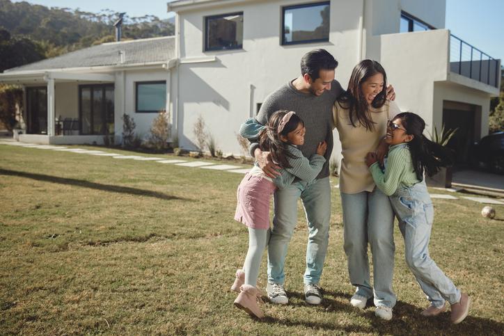 A family enjoying time outside their home they just refinanced.