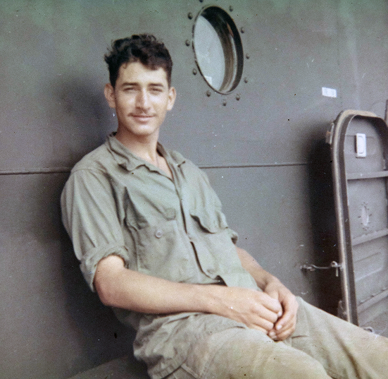 David Rodriguez sitting in military fatigues aboard a vessel.