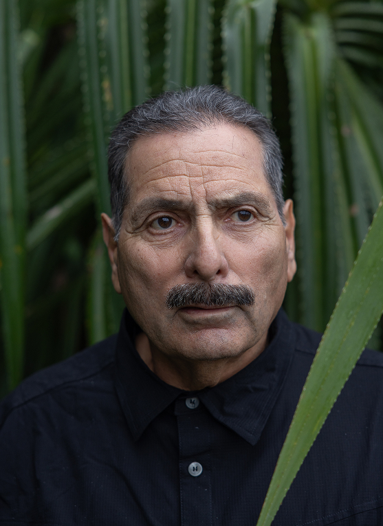 Esteban Valenzuela in a close-up portrait outdoors among tropical vegetation.