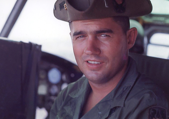 Richard "Rich" Michael Coachys smiling in a military uniform seated in a cockpit.
