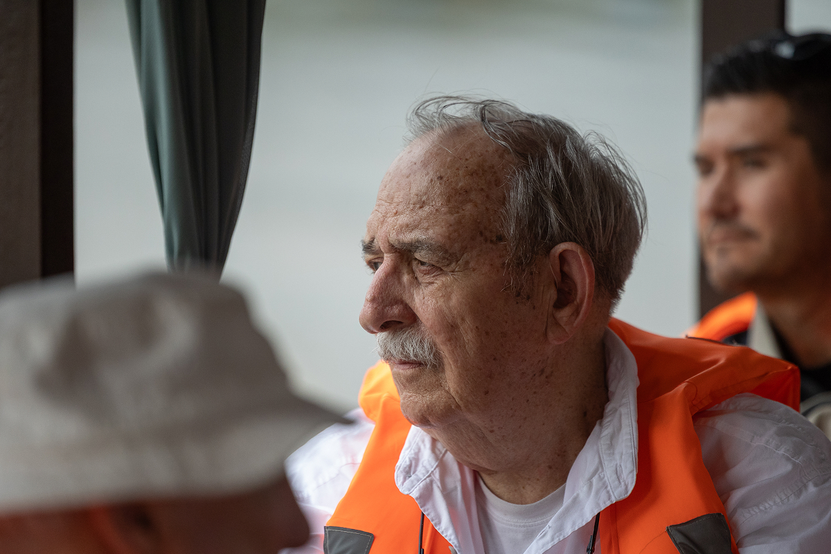 Mike Gilpin wearing a life vest, gazing out from a boat on a river in Vietnam